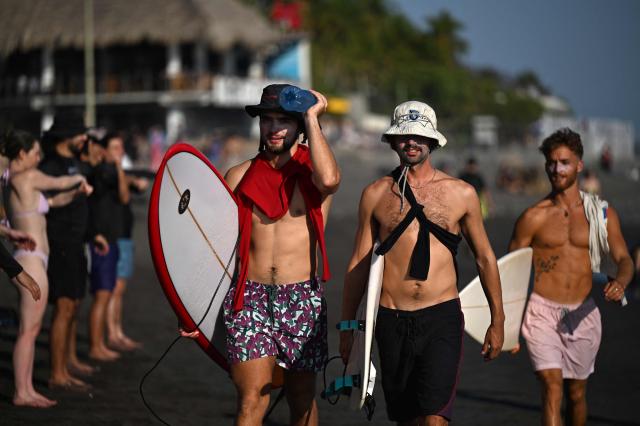 Tourists enjoy El Tunco beach, in La Libertad, El Salvador, on February 13, 2026. Amid picture-perfect waves and sunsets, foreign tourists enjoy the Salvadoran beach of El Tunco, once plagued by gang violence. They are full of praise for President Nayib Bukele, even though they admit that innocent people may have been caught up in his crackdown. (Photo by Marvin RECINOS / AFP)