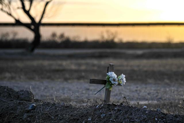 A cross marks the grave of an unknown migrant at a cemetery adjacent to the US-Mexico border wall in Quemado, Texas, on February 18, 2026. (Photo by RONALDO SCHEMIDT / AFP)