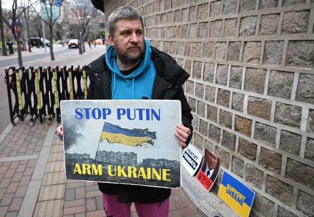 A Russian protester holds a placard as he condemns Russia's invasion of Ukraine near the Russian embassy in Seoul on February 24, 2026, on the 4th anniversary of the Russia-Ukraine war. (Photo by Jung Yeon-je / AFP)