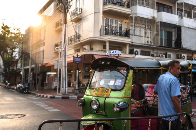A tuk tuk driver stands beside his vehicle in Bangkok on February 24, 2026. (Photo by chanakarn laosarakham / AFP)