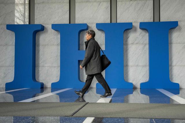 A man walks past the logo of IHI Corporation at the company's headquarters in Tokyo on February 24, 2026. (Photo by Yuichi YAMAZAKI / AFP)
