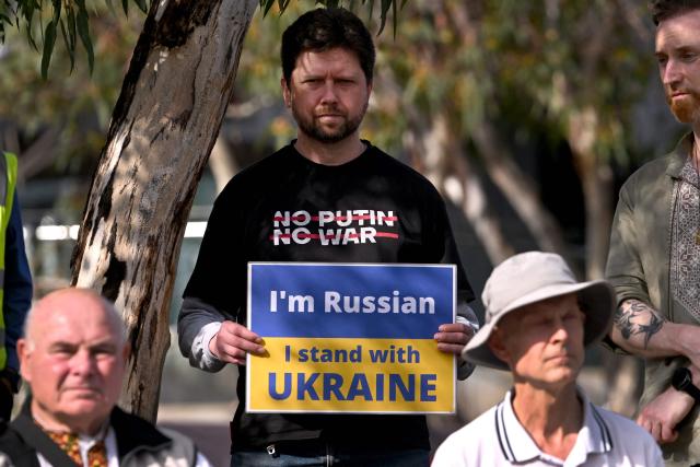 A demonstrator holds up a placard during a rally to mark the fourth anniversary of the Russia-Ukraine war, in Melbourne on February 24, 2026. (Photo by William WEST / AFP)