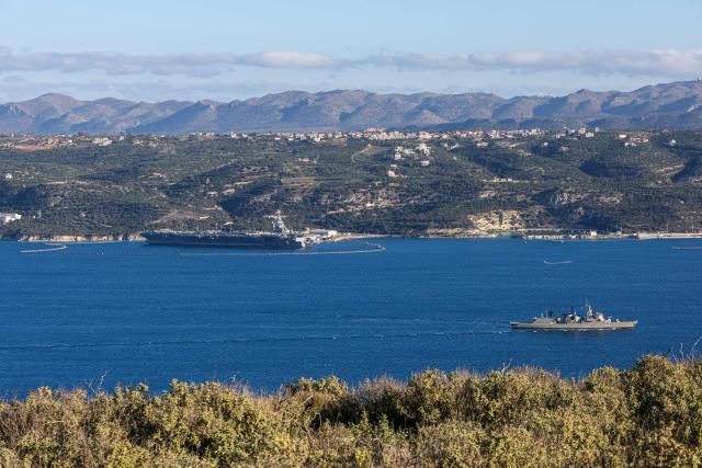 US aircraft carrier USS Gerald Ford (L) is pictured docked at Souda Bay in the Greek Mediterranean island of Crete, on February 24, 2026. Upon military orders by US President Donald Trump, the world's largest vessel is on its way to the Middle East to join 13 more warships stationed in the region: the aircraft carrier USS Abraham Lincoln, which arrived late last month, nine destroyers and three frigates. (Photo by Costas METAXAKIS / AFP)