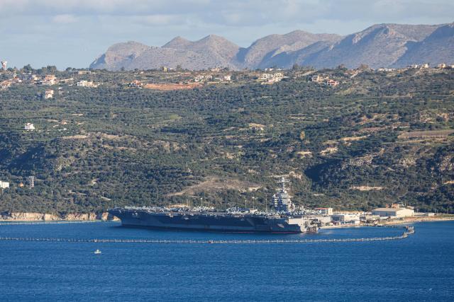 US aircraft carrier USS Gerald Ford is pictured docked at Souda Bay in the Greek Mediterranean island of Crete, on February 24, 2026. Upon military orders by US President Donald Trump, the world's largest vessel is on its way to the Middle East to join 13 more warships stationed in the region: the aircraft carrier USS Abraham Lincoln, which arrived late last month, nine destroyers and three frigates. (Photo by Costas METAXAKIS / AFP)