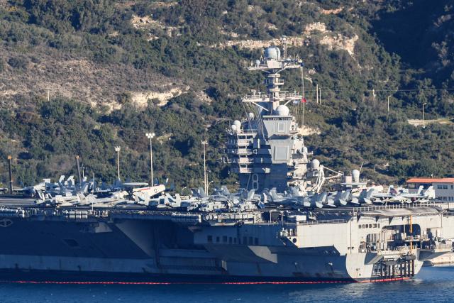 US aircraft carrier USS Gerald Ford is pictured docked at Souda Bay in the Greek Mediterranean island of Crete, on February 24, 2026. Upon military orders by US President Donald Trump, the world's largest vessel is on its way to the Middle East to join 13 more warships stationed in the region: the aircraft carrier USS Abraham Lincoln, which arrived late last month, nine destroyers and three frigates. (Photo by Costas METAXAKIS / AFP)