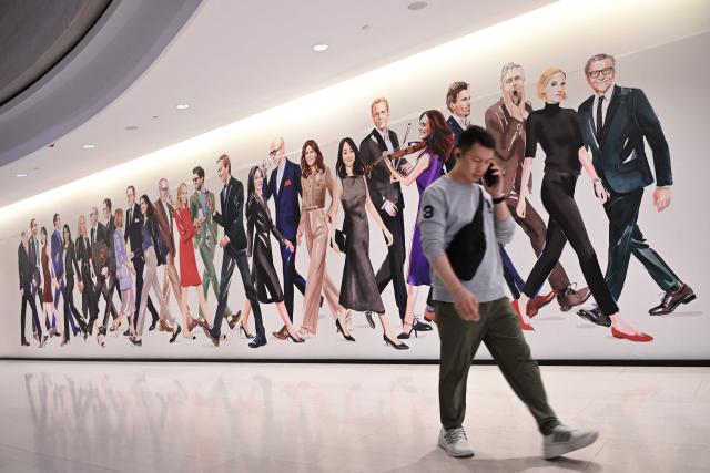 A shopper walks past a mural at a shopping centre in Hong Kong on February 24, 2026, a day before the Hong Budget is announced. (Photo by Peter PARKS / AFP)