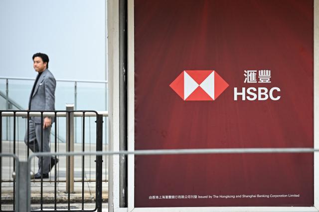 A man walks past the HSBC bank headquarters in Hong Kong on February 24, 2026, a day before the bank's annual results are announced. (Photo by Peter PARKS / AFP)