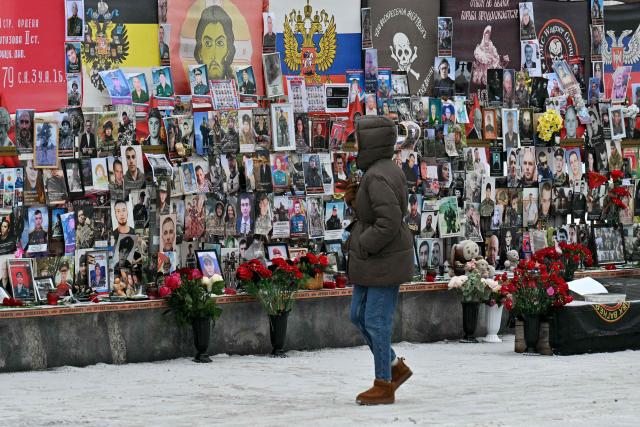 A person walks past a memorial for the fallen Russian soldiers, including Russia's Wagner paramilitary group fighters, on a street in Moscow on February 24, 2026, on the fourth anniversary of the ongoing Russia-Ukraine conflict. (Photo by HECTOR RETAMAL / AFP)