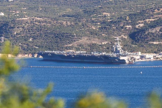 US aircraft carrier USS Gerald Ford is pictured docked at Souda Bay in the Greek Mediterranean island of Crete, on February 24, 2026. Upon military orders by US President Donald Trump, the world's largest vessel is on its way to the Middle East to join 13 more warships stationed in the region: the aircraft carrier USS Abraham Lincoln, which arrived late last month, nine destroyers and three frigates. (Photo by Costas METAXAKIS / AFP)