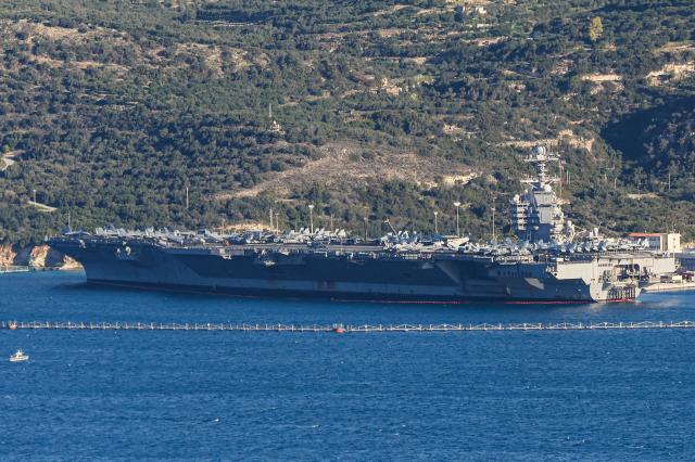 US aircraft carrier USS Gerald Ford is pictured docked at Souda Bay in the Greek Mediterranean island of Crete, on February 24, 2026. Upon military orders by US President Donald Trump, the world's largest vessel is on its way to the Middle East to join 13 more warships stationed in the region: the aircraft carrier USS Abraham Lincoln, which arrived late last month, nine destroyers and three frigates. (Photo by Costas METAXAKIS / AFP)