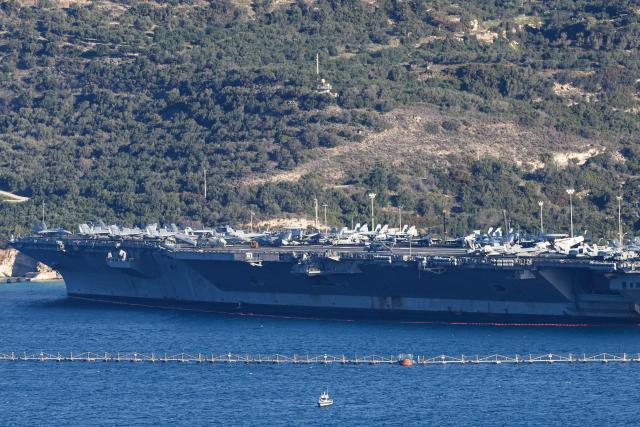 US aircraft carrier USS Gerald Ford is pictured docked at Souda Bay in the Greek Mediterranean island of Crete, on February 24, 2026. Upon military orders by US President Donald Trump, the world's largest vessel is on its way to the Middle East to join 13 more warships stationed in the region: the aircraft carrier USS Abraham Lincoln, which arrived late last month, nine destroyers and three frigates. (Photo by Costas METAXAKIS / AFP)