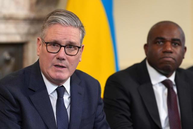 Britain's Prime Minister Keir Starmer, flanked by Britain's Justice Secretary and deputy Prime Minister David Lammy, delivers remarks at the top of a Cabinet meeting inside 10 Downing Street in London, on February 24, 2026, to mark the fourth anniversary of Russia's full-scale invasion of Ukraine. (Photo by Kin Cheung / POOL / AFP)
