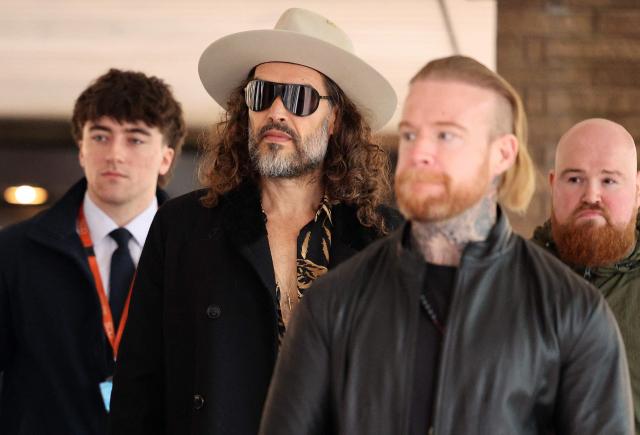 British comedian and actor Russell Brand (2L) leaves Southwark Crown Court in south London on February 24, 2026 after attending a one-day plea and trial preparation hearing at . (Photo by Adrian Dennis / AFP)
