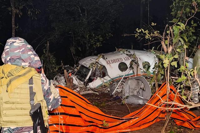 Security personnel stand near the wreckage of the Beechcraft C90 air ambulance aircraft, the night after it crashed near a forest at Chatra district in Jharkahand state on February 24, 2026. Seven people were killed when a chartered air ambulance crashed in the eastern Indian state of Jharkhand, officials said on February 24. (Photo by Rajesh KUMAR / AFP)