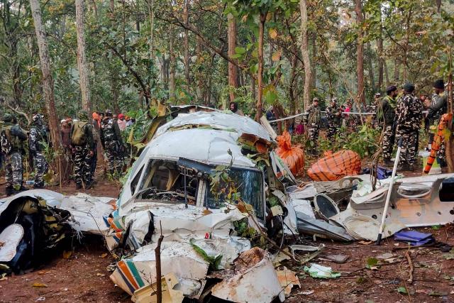 Security personnel stand near the wreckage of the Beechcraft C90 air ambulance aircraft, the night after it crashed near a forest at Chatra district in Jharkahand state on February 24, 2026. Seven people were killed when a chartered air ambulance crashed in the eastern Indian state of Jharkhand, officials said on February 24. (Photo by Rajesh KUMAR / AFP)