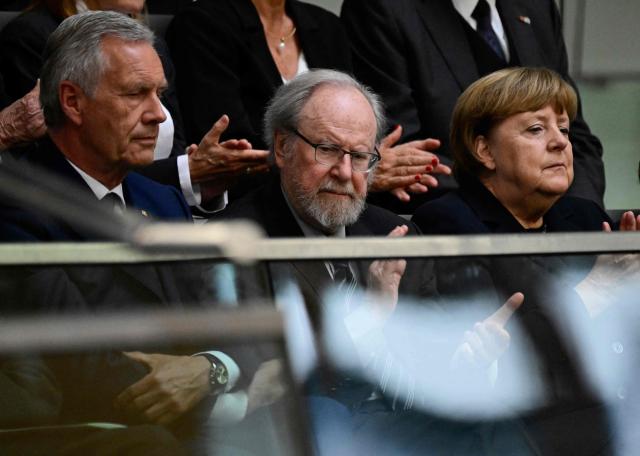 (L-R) Member of Germany's Christian Democratic Union (CDU) and former German President Christian Wulff, former German Bundestag President Wolfgang Thierse and former German chancellor Angela Merkel attend a commemoration ceremony for late former Bundestag President Rita Suessmuth at the Bundestag (lower house of parliament) in Berlin, on February 24, 2026. (Photo by John MACDOUGALL / AFP)