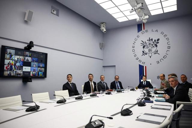 French President Emmanuel Macron (C-R) participates in a video-conference meeting of Ukraine's 'Coalition of the Willing', co-chaired by him and British Prime Minister Keir Starmer (not pictured), at the Elysee Presidential Palace in Paris on February 24, 2026. (Photo by Sarah Meyssonnier / POOL / AFP)