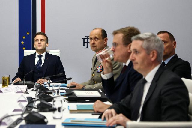 French President Emmanuel Macron (L) participates in a video-conference meeting of Ukraine's 'Coalition of the Willing', co-chaired by him and British Prime Minister Keir Starmer (not pictured), at the Elysee Presidential Palace in Paris on February 24, 2026. (Photo by Sarah Meyssonnier / POOL / AFP)