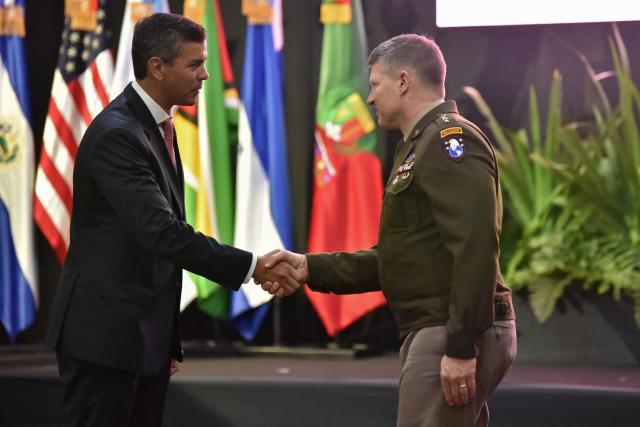 Paraguay's President Santiago Pena (L) shakes hands with the commanding general of the U.S. Army Western Hemisphere Command Joseph A. Ryan during the opening of the XXXVII Cycle (2026–2027) of the Conference of American Armies (CAA) in Asuncion, on February 24, 2026. (Photo by Daniel Duarte / AFP)