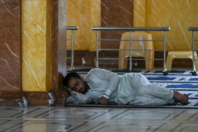 A Muslim devotee takes a nap during the Islamic holy fasting month of Ramadan at the New Memon Mosque in Karachi on February 24, 2026. (Photo by Asif HASSAN / AFP)