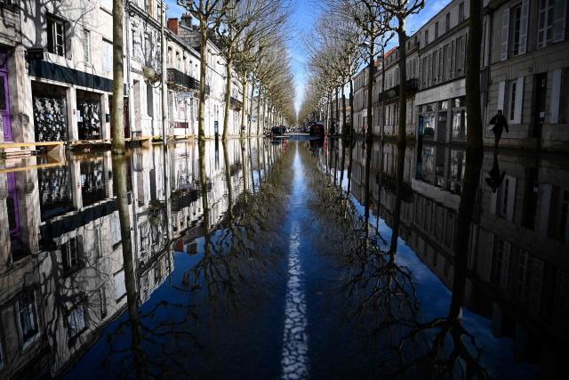 Water floods the banks of the Charente River following severe flooding caused by Storm Nils in Saintes, south-western France, on February 24, 2026. (Photo by Christophe ARCHAMBAULT / AFP)