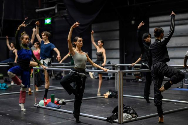 Dancers of the 'Bejart Ballet Lausanne' (BBL) of Switzerland, dance during a training session on the sidelines of the three unique ballets brought together at Zorlu Performing Arts Center (PSM) in Istanbul on February 20, 2026. Thirty-six dancers with raised arms glide slowly forward as they encircle their prey, a lone figure on a red table in a climactic scene from Ravel's "Bolero" choreographed by Maurice Bejart. (Photo by Yasin AKGUL / AFP)