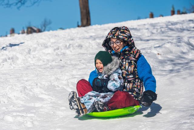Families sled down the snow covered Flagstaff Hill in Boston Common in Boston, Massachusetts on February 24, 2026. More than 40 million people were under weather warnings in the northeastern United States, as a winter storm dumped shin-deep snow and officials enforced travel bans and school closures in several cities. The so-called "Nor'easter" pummeled the region, disrupting flights and leaving hundreds of thousands of homes and businesses without power. (Photo by Joseph Prezioso / AFP)