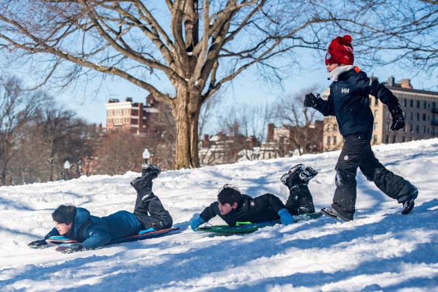 Children sled down the snow covered Flagstaff Hill in Boston Common in Boston, Massachusetts on February 24, 2026. More than 40 million people were under weather warnings in the northeastern United States, as a winter storm dumped shin-deep snow and officials enforced travel bans and school closures in several cities. The so-called "Nor'easter" pummeled the region, disrupting flights and leaving hundreds of thousands of homes and businesses without power. (Photo by Joseph Prezioso / AFP)