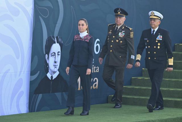 Mexico’s President Claudia Sheinbaum (L), Minister of Defence Ricardo Trevilla Trejo (C) and Navy Admiral Raymundo Pedro Morales Angeles walk during the celebration of Flag Day in Mexico City on February 24, 2026. Sheinbaum offered "full guarantees" for the safety of football fans at World Cup games in the violence-plagued city of Guadalajara on February 24. (Photo by YURI CORTEZ / AFP)