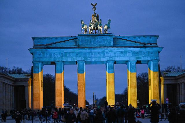 Berlin's landmark Brandenburg Gate is illuminated in the colours of Ukraine"s flag, marking the 4th anniversary of Russia's full-scale invasion of Ukraine in front of  in Berlin, on February 24, 2026. (Photo by RALF HIRSCHBERGER / AFP)