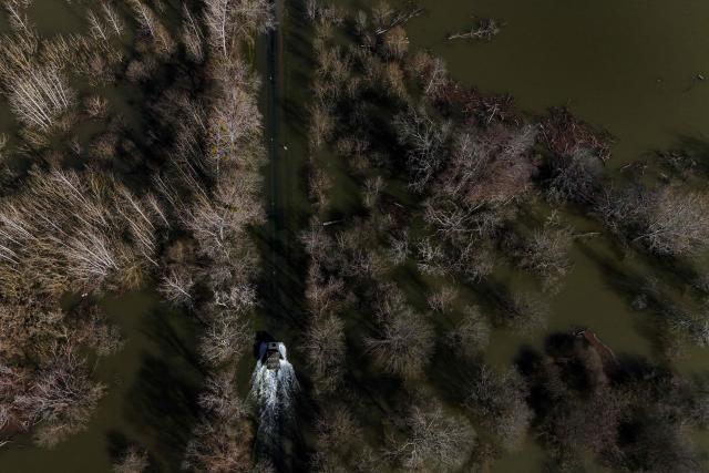 This aerial picture shows a French gendarmerie 4x4 vehicle transporting residents making its way through a flooded from the flood-isolated village of Courcoury towards neighboring Courpignac on February 24, 2026, as the Charente-Maritime commune in south-western France remains surrounded by floodwaters following storm Nils. (Photo by Christophe ARCHAMBAULT / AFP)