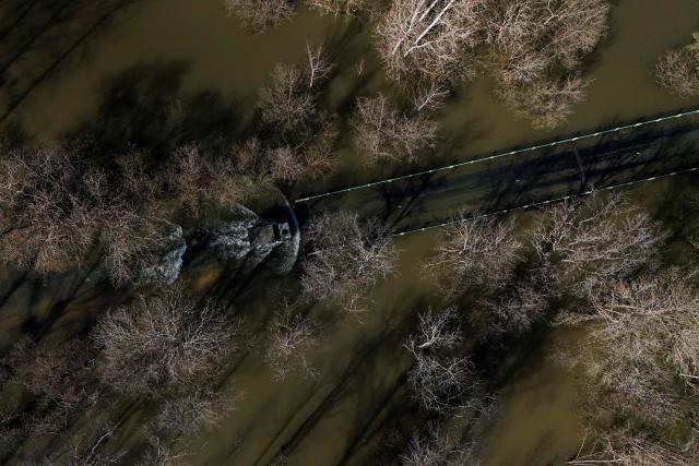 This aerial picture shows a French gendarmerie 4x4 vehicle transporting residents making its way through a flooded from the flood-isolated village of Courcoury towards neighboring Courpignac on February 24, 2026, as the Charente-Maritime commune in south-western France remains surrounded by floodwaters following storm Nils. (Photo by Christophe ARCHAMBAULT / AFP)