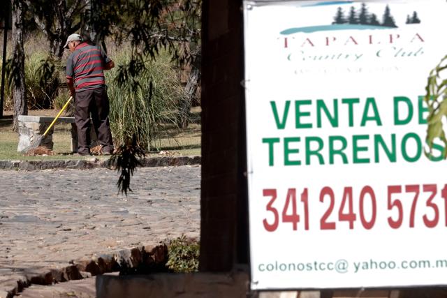 A gardener works the “Tapalpa Country Club”, where Mexican drug lord "El Mencho” was hiding at the moment of the operation in which he was killed, in Tapalpa, Jalisco state, Mexico, on February 24, 2026. Residents of Jalisco cautiously peeked their heads out on February 23, 2026 after waves of retaliatory cartel violence rocked the Mexican state over the weekend following the death of a major drug kingpin. (Photo by Ulises RUIZ / AFP)