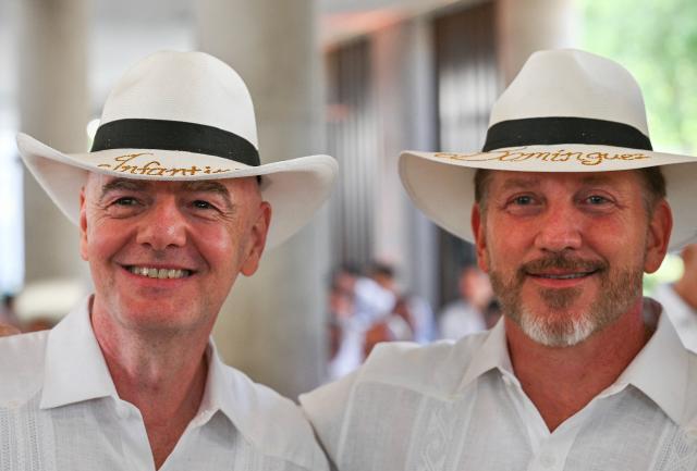FIFA president Gianni Infantino (L) and CONMEBOL president Alejandro Dominguez wear typical Colombian hats reading ‘Infantino’ and ‘Dominguez’ during their visit to the new Concentration Hotel of the Colombian Football Federation, in Barranquilla on February 24, 2026. FIFA boss Gianni Infantino told AFP on February 24, 2026, he was "very reassured" about Mexico's hosting of games in the World Cup, in his first comments on the violence triggered by the killing of a drug cartel leader. (Photo by David SALAZAR / AFP)