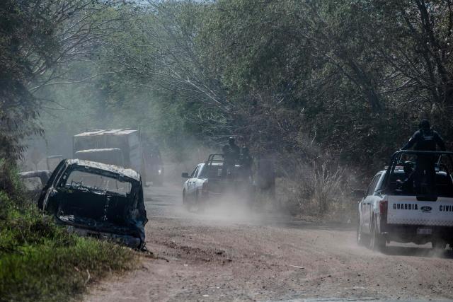 A brunt truck is seen as members of the Civil Guard of Michoacan patrol a highway after a wave of violence in the town of Aguililla, the birthplace of drug kingpin Nemesio Oseguera, leader of the Jalisco New Generation Cartel (CJNG) in Tierra Caliente, Mexico, on February 24, 2026. Mexican President Claudia Sheinbaum on February 24 dismissed risks to fans visiting Guadalajara, one of the venues for the 2026 World Cup, after a drug cartel riot caused fear in the city and much of the country on February 22. (Photo by Enrique Castro / AFP)