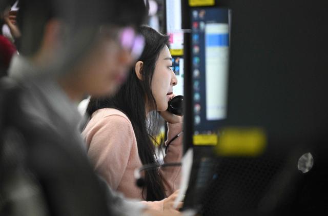 Currency dealers monitor exchange rates in a foreign exchange dealing room at the Hana Bank headquarters in Seoul on February 25, 2026. South Korea's benchmark Kospi index topped 6,000 points for the first time on February 25, buoyed by the strong performance of the nation's world-leading semiconductor industry. (Photo by Jung Yeon-je / AFP)