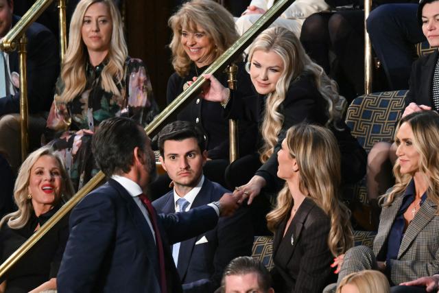 Erika Kirk, widow of the late conservative activist Charlie Kirk, shakes hands with Donald Trump Jr., before the arrival of US President Donald Trump for the State of the Union address in the House Chamber of the US Capitol in Washington, DC, on February 24, 2026. (Photo by ANDREW CABALLERO-REYNOLDS / AFP)