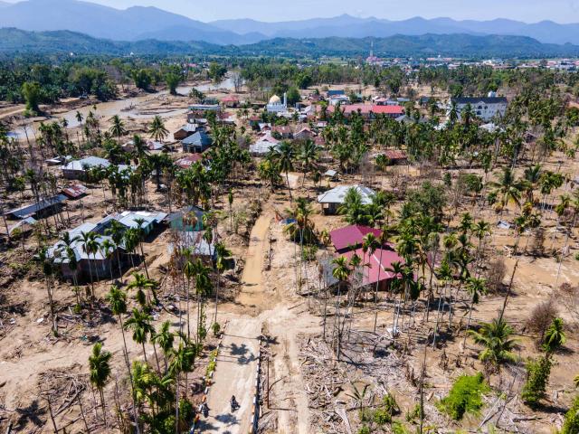 An aerial view shows flood damage to a residential area in Meurah Dua, Aceh province's Pidie Jaya district on February 22, 2026, after devastating floods and landslides struck Indonesia's Sumatra late last year. Some 32,000 flood survivors remain displaced following the late 2025 monsoon deluge. In hardest-hit Aceh province, which accounted for most of the more than 1,000 deaths, families have become increasingly frustrated over authorities' sluggish response. Many remain crammed in temporary shelters or a cluster of tents, with little expectation of returning to their mud-caked homes any time soon. (Photo by CHAIDEER MAHYUDDIN / AFP) / To go with AFP story Indonesia-flood by Alfath Asmunda