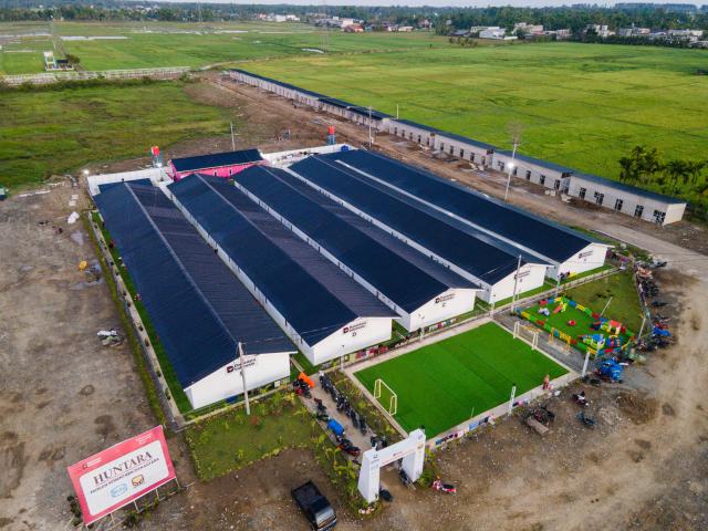 An aerial view shows temporary housing built by Indonesian state-owned investment agency Danantara for flood survivors in Meureudu, Aceh province's Pidie Jaya district on February 22, 2026, after devastating floods and landslides struck Indonesia's Sumatra late last year. Some 32,000 flood survivors remain displaced following the late 2025 monsoon deluge. In hardest-hit Aceh province, which accounted for most of the more than 1,000 deaths, families have become increasingly frustrated over authorities' sluggish response. Many remain crammed in temporary shelters or a cluster of tents, with little expectation of returning to their mud-caked homes any time soon. (Photo by CHAIDEER MAHYUDDIN / AFP) / To go with AFP story Indonesia-flood by Alfath Asmunda