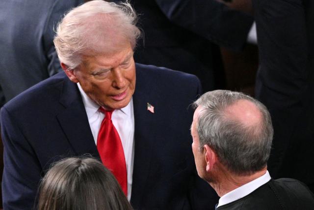 US President Donald Trump greets Supreme Court Chief Justice John Roberts as Trump arrives to deliver his State of the Union address in the House Chamber of the US Capitol in Washington, DC, on February 24, 2026. (Photo by Mandel NGAN / AFP)