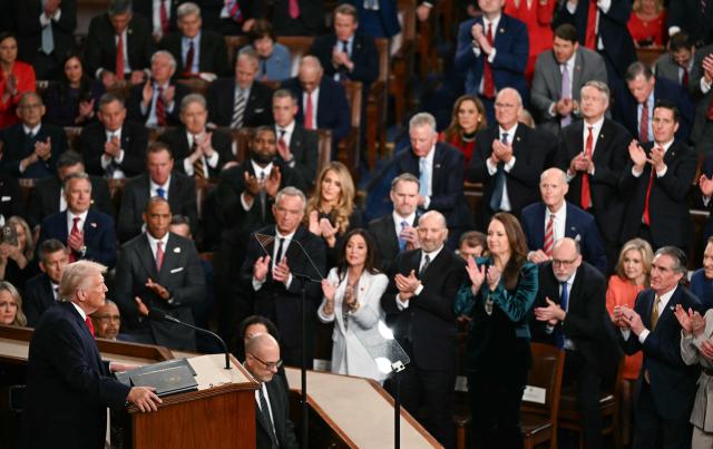 Members of Congress stand up and applaud as US President Donald Trump (L) delivers the State of the Union address in the House Chamber of the US Capitol in Washington, DC, on February 24, 2026. (Photo by Brendan SMIALOWSKI / AFP)