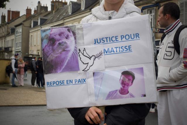 (FILES) A mourner holds a placard that reads, "Justice for Matisse, Rest in peace", during a commemorative 'Marche Blanche' (White March) to pay tribute to 15-year-old Matisse, who died after being stabbed during an altercation, in Chateauroux, central France, on May 4, 2024. The mother of the teenager sentenced to eight years in prison for the murder of Matisse, who was killed at 15 years old by several stab wounds in April 2024 in Chateauroux, will in turn be tried on February 27, 2026, suspected of having also struck the victim. (Photo by GUILLAUME SOUVANT / AFP)