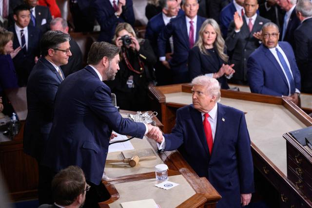 US President Donald Trump shakes hands with US Vice President JD Vance (C) watched by House Speaker Mike Johnson, R-LA, as he arrives to deliver the State of the Union address in the House Chamber of the US Capitol in Washington, DC on February 24, 2026. (Photo by Mandel NGAN / AFP)