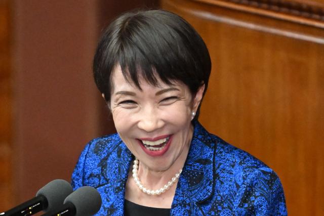 Japan's Prime Minister Sanae Takaichi smiles as she answers questions from Yuichiro Tamaki, head of the Democratic Party for the People, during a plenary session of the House of Representatives in Tokyo on February 25, 2026. (Photo by Kazuhiro NOGI / AFP)