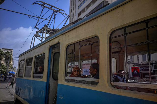 Commuters sit inside a tram in the coastal city of Alexandria on February 18, 2026. Along Egypt's Mediterranean coast, the oldest tram in Africa and the Middle East rumbles for a final few weeks before its removal -- the latest urban upheaval Alexandrians say is hollowing out their city's identity. Inaugurated in 1863, the tram is one of the world's oldest, and among only a few to operate double-decker cars. (Photo by Khaled DESOUKI / AFP)