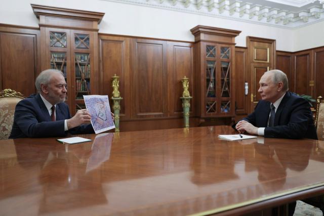 In this pool photograph distributed by the Russian state agency Sputnik, Russia's President Vladimir Putin (R) attends a meeting with General Director of the Bolshoi Theatre Valery Gergiev (L) in Moscow on February 25, 2026.  (Photo by Gavriil GRIGOROV / POOL / AFP)