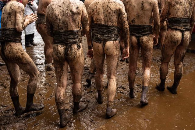 Participants are seen covered with mud during the Warabi Hadaka festival at Mimusubi shrine in Yotsukaido, Chiba Prefecture on February 25, 2026. (Photo by Yuichi YAMAZAKI / AFP)