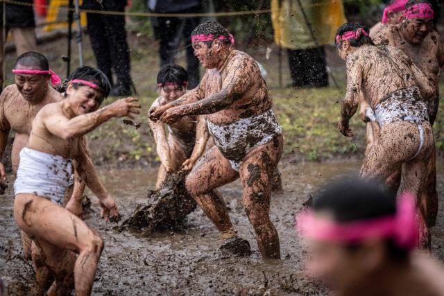 Participants hurl mud at one another during the Warabi Hadaka festival in Yotsukaido, Chiba Prefecture on February 25, 2026. (Photo by Yuichi YAMAZAKI / AFP)