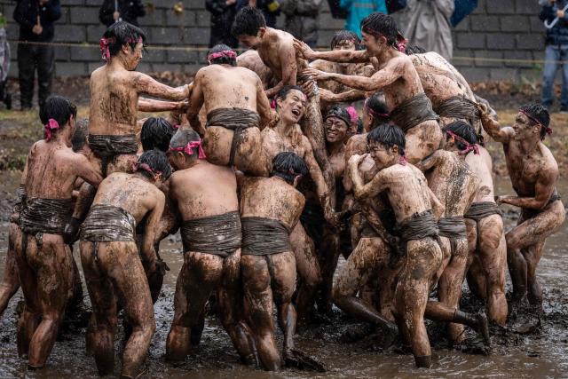 Participants take part in a horseback-style battle in a muddy field during the Warabi Hadaka festival in Yotsukaido, Chiba Prefecture on February 25, 2026. (Photo by Yuichi YAMAZAKI / AFP)