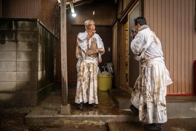 Participants wipe mud from their faces during the Warabi Hadaka festival at Mimusubi shrine in Yotsukaido, Chiba Prefecture on February 25, 2026. (Photo by Yuichi YAMAZAKI / AFP)